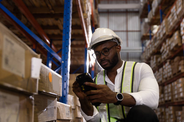 istock Black male staff using digital barcode scanner working checking stock in logistic warehouse 1463069602