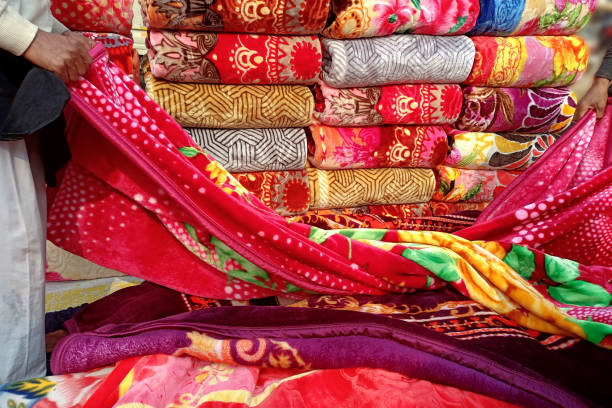 un vendedor exhibiendo mantas de colores en un puesto improvisado al borde de la carretera - tienda de telas fotografías e imágenes de stock