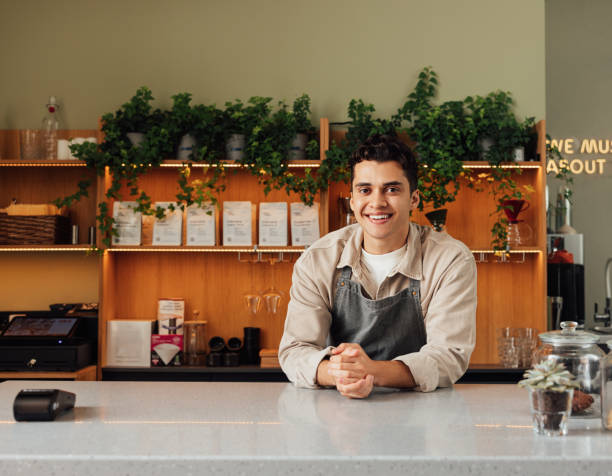 istock Smiling coffee shop owner in apron leaning a counter. Middle eastern bartender looking at camera. 1463076521
