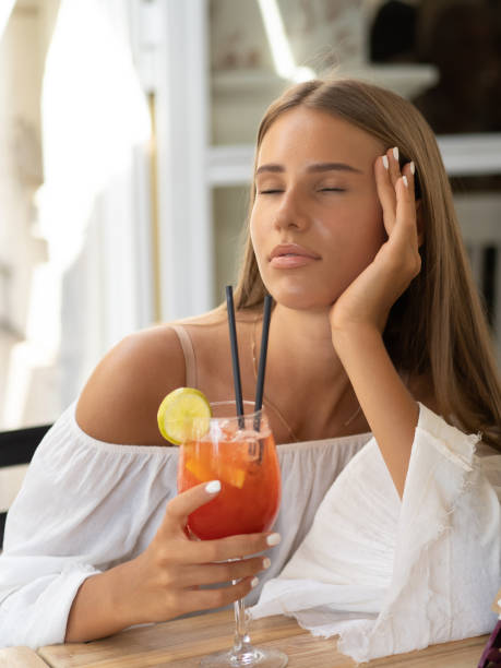 istock A young elegant woman holds a cocktail while sitting outside in summer 1463080023