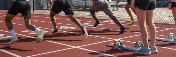 istock Four runners sprinting from the blocks at track practice 1463080065