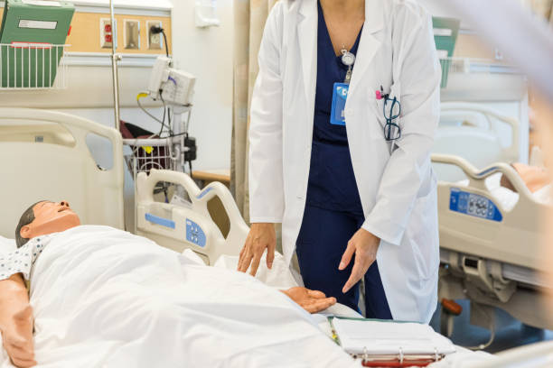 istock Unrecognizeable doctor stands bedside to the mannequin in the classroom 1463083761