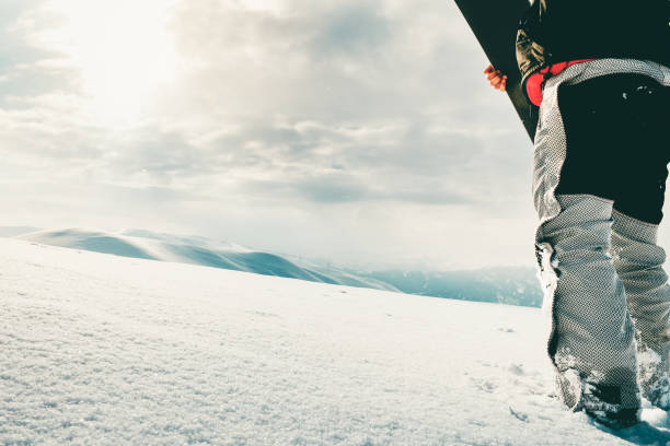 istock Snowboarder dressed in a full protective gear for extreme freeride snowboarding posing with a snowboard walking. Isolated on gray white snow background. 1463086700