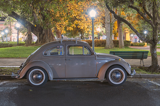 Poços de Caldas, Minas Gerais, Brazil. January 26, 2023. Old gray Volkswagen Beetle from the early 1970's parked in the street at night.