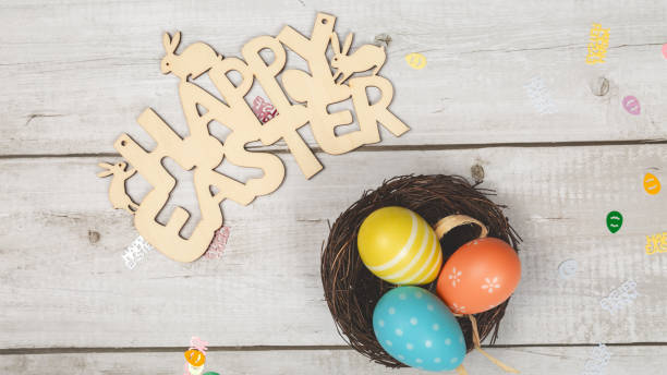 istock greeting card with text happy easter. multicolored easter eggs on white wooden background 1463088528