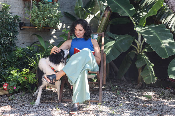 istock Latin woman reading and playing with dog 1463090758