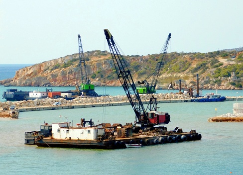 Floating crane dredging barges working in the construction of a marina, at Vouliagmeni, Athens, Greece