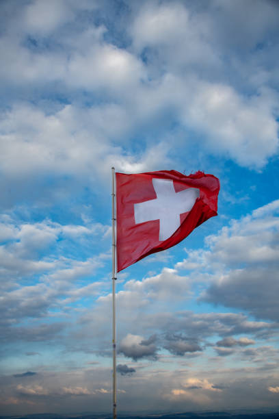 istock Swiss flag blowing in the wind, the background is a cloudy sky 1463095473