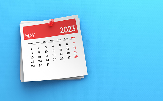 2023 Post it note May Calendar and Red Push Pin on Blue Paper Background stock photo