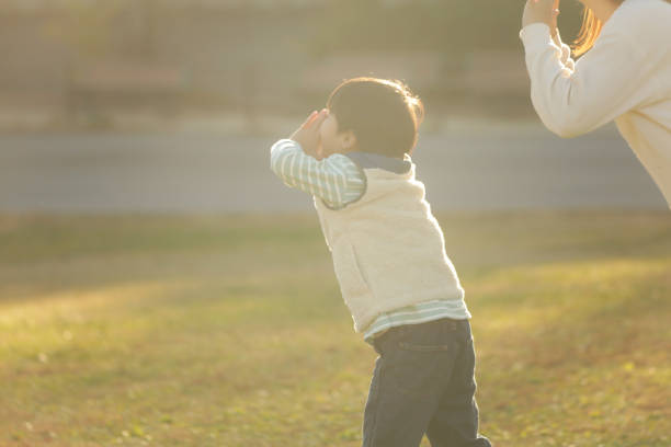 A group of happy children play a game of passing through their legs in an autumn park