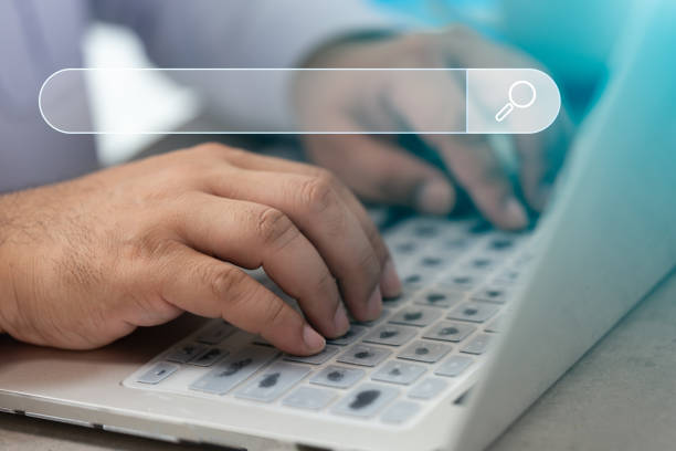 istock Man hand working with computer laptop with icon of searching browsing internet data information with blank search bar. 1463104298