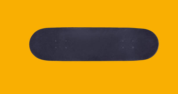 Close up surface black skateboard isolated on yellow background, flat lay, top view stock photo