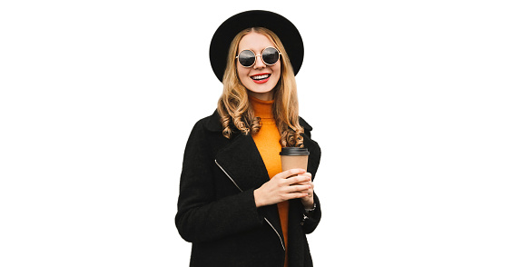 Portrait of stylish happy smiling young woman with cup of coffee wearing black coat, round hat isolated on white background