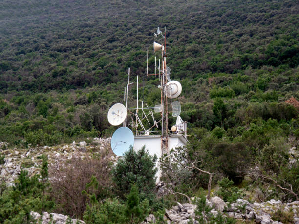 istock Radio retranslator tower with satellite dish antennas on green hillside 1463106277