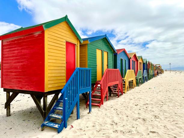 знаменитые цветные дома на пляже мюйзенберг, кейптаун, южная африка - lions head mountain стоковые фото и изображения