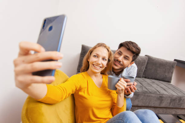 istock couple drinking coffee and taking selfie 1463110528