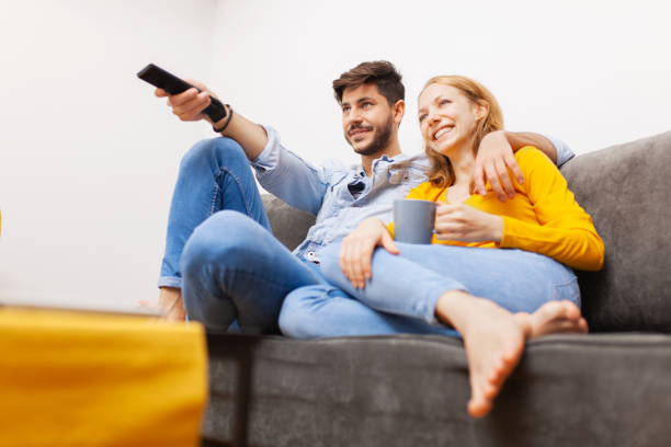 couple in love watching tv stock photo