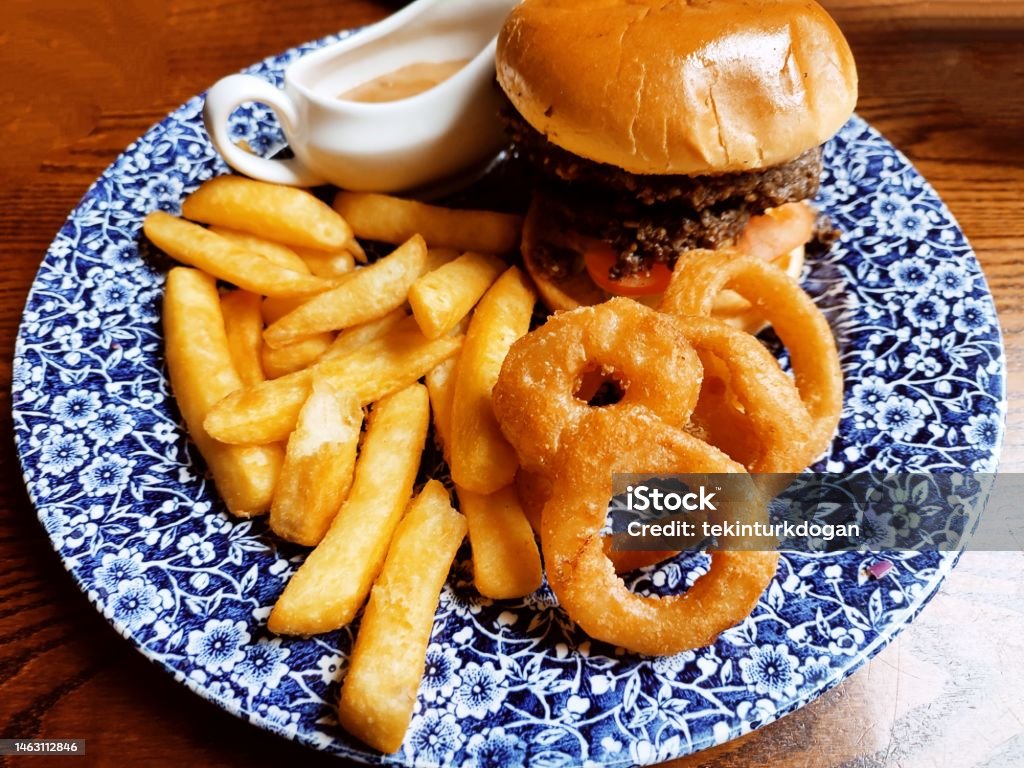 Traditional hamburger with french fries potato chips onion rings at glasgow scotland england uk Prepared Potato Stock Photo