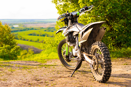 Voronezh, Russia - May 10, 2022: The Avantis 300 Limited Edition enduro motorcycle stands on a hilltop above a valley with a river at sunset. Selective focus