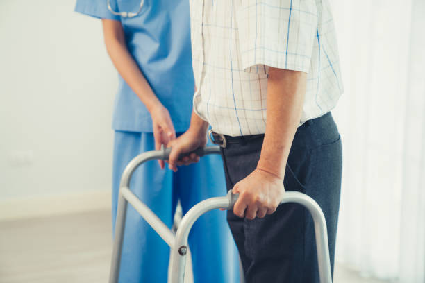 istock Physiotherapist assists her contented senior patient on folding walker. 1463121226