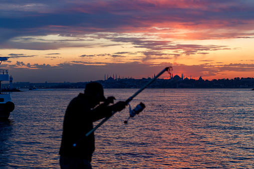silhouettes of people by sunset and night at sea coast