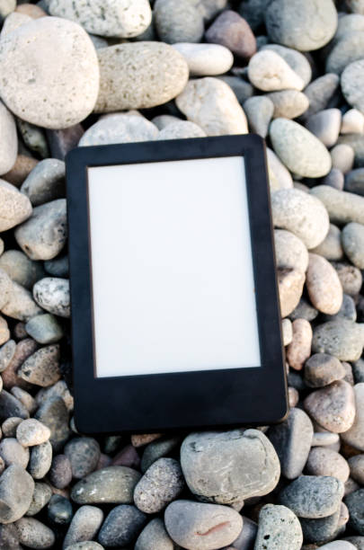 Gadget, e-book lies on the pebbles, on the beach