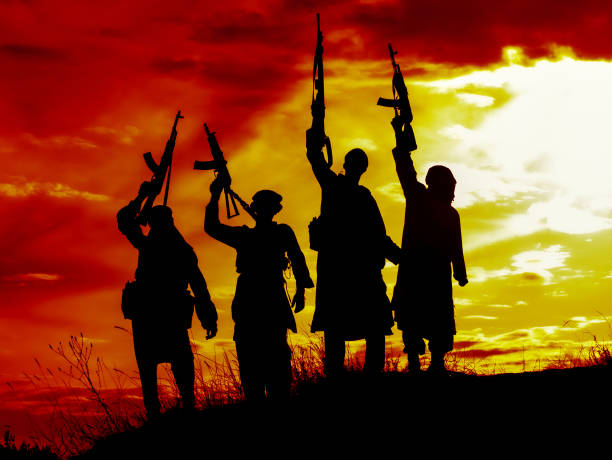 Silhouette of several muslim militants with rifles stock photo