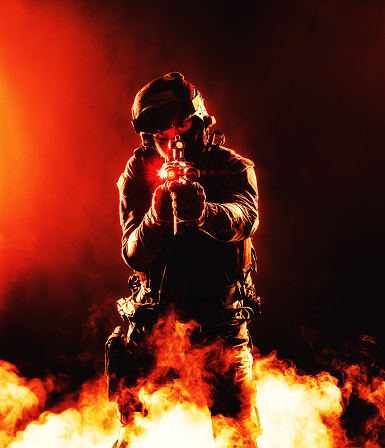 A silhouette of a soldier in fire and smoke, danger and intensity of battle. Dark outline in flames and billowing smoke, chaos and destruction of war. Respect for the sacrifices made by soldiers in defense of their country motherland.