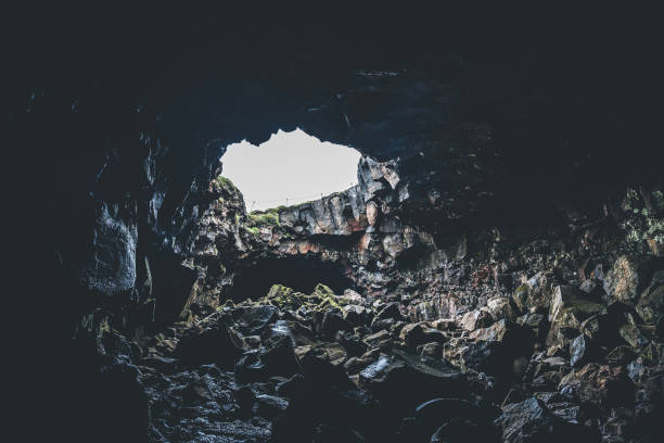istock Cave with opening and light coming through. Walking through lava cave in Iceland 1463125693