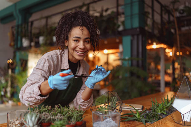 istock Woman florist making succulent plant composition at floral design studio and looking at camera 1463126421