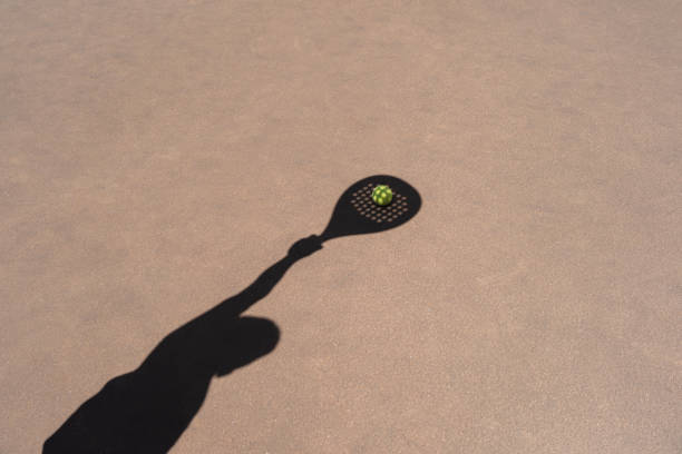 Shadow of padel racket over ball stock photo