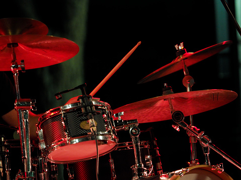 Close-up of two wooden drumsticks on an old metallic snare drum and golden colored cymbal with copy space. Percussion instrument