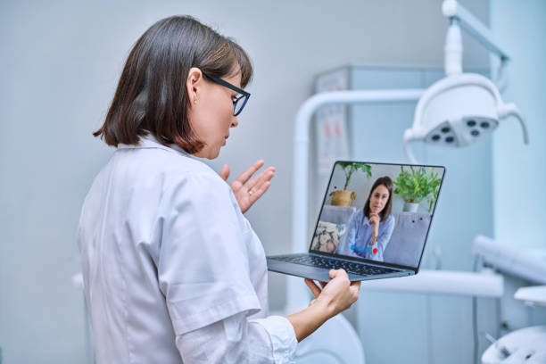 istock Doctor dentist working in office, using laptop, making video call conference 1463138684