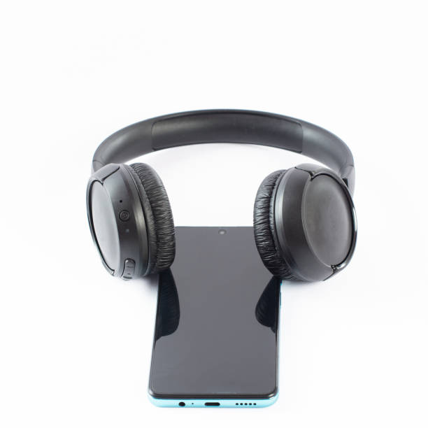 istock Wireless headphones with a phone on a white background. 1463139937