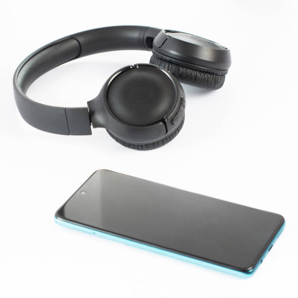 istock Wireless headphones with a phone on a white background. 1463139985