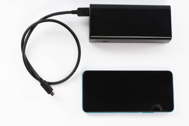 istock power bank with charging cable and phone, copy space and white background. 1463140307