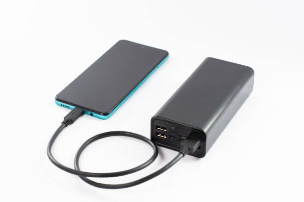 istock power bank with charging cable and phone, copy space and white background. 1463140387
