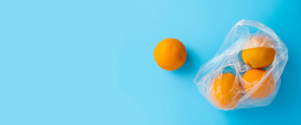 istock Fresh ripe oranges in a transparent plastic bag on a blue background. Top view, flat lay. Banner 1463142578