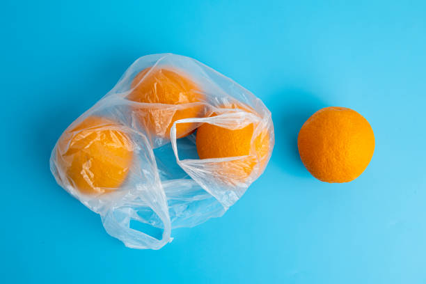 istock Fresh ripe oranges in a transparent plastic bag on a blue background. Top view, flat lay 1463143894