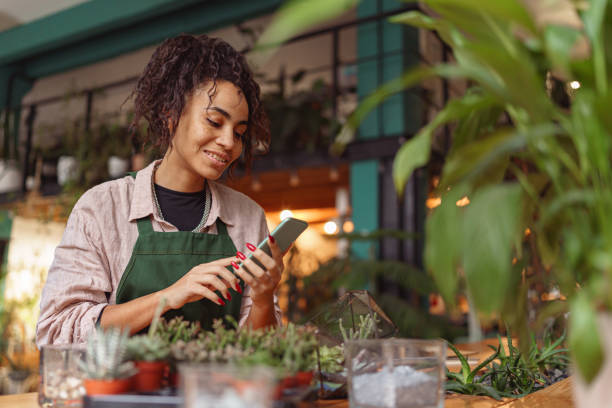 istock Woman florist use mobile phone during working day in floral design studio 1463152997
