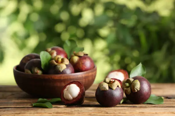Delicious tropical mangosteen fruits on wooden table
