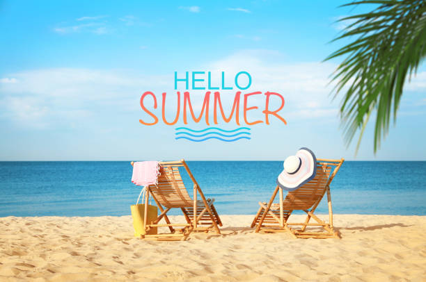 istock Hello Summer. Empty wooden sunbeds and beach accessories on sandy shore 1463164755