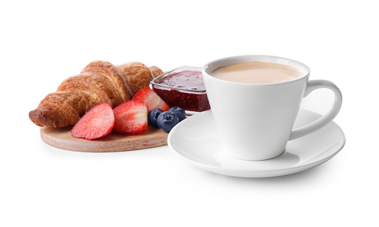 Tasty croissant, cup of coffee, fruits and jam on white background