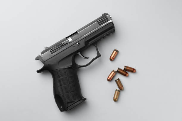 istock Semi-automatic pistol and bullets on light background, flat lay 1463175147