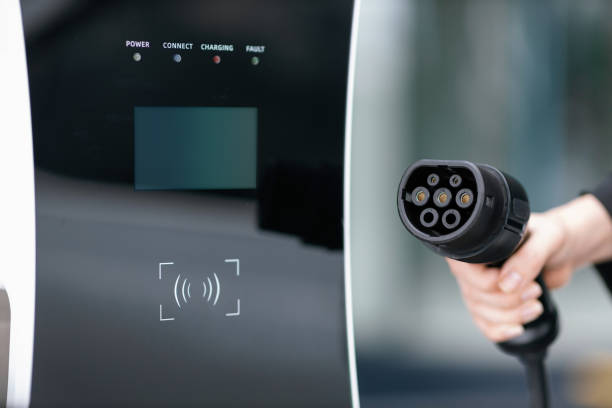 istock Focus closeup hand pointing EV plug for electric vehicle as progressive idea. 1463175621
