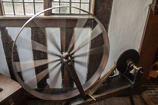 An old spinning loom with the wheel caught in motion