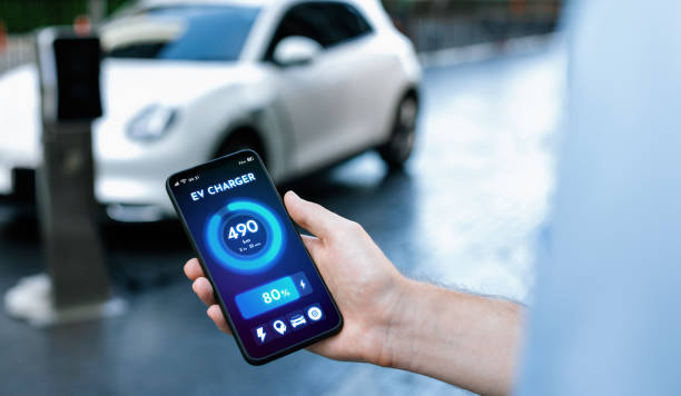 Closeup progressive idea hand holding smart phone display EV's batter status.
