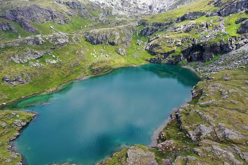 A beautiful mountain lake in vibrant blue color seen from above. The image was captured at an altitude of 2'200m in the swiss alps (canton of glarus)