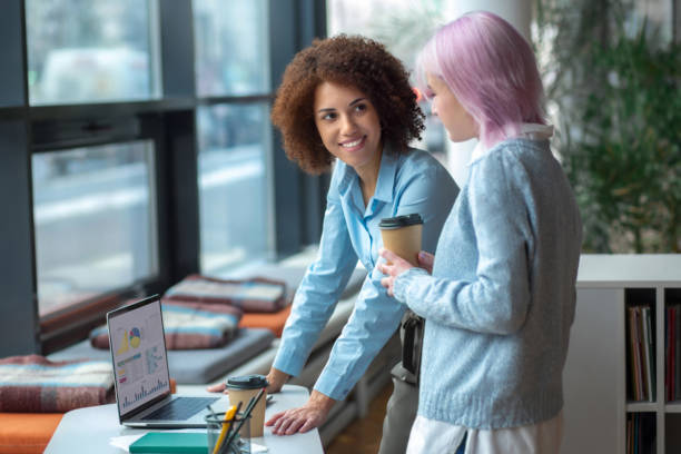 istock Two young modern business women entrepreneurs discussing something and smiling while working in the creative office. Achieving success together 1463186595