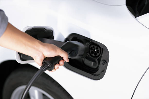istock Closeup focus hand insert EV charger to progressive electric rechargeable car. 1463189310